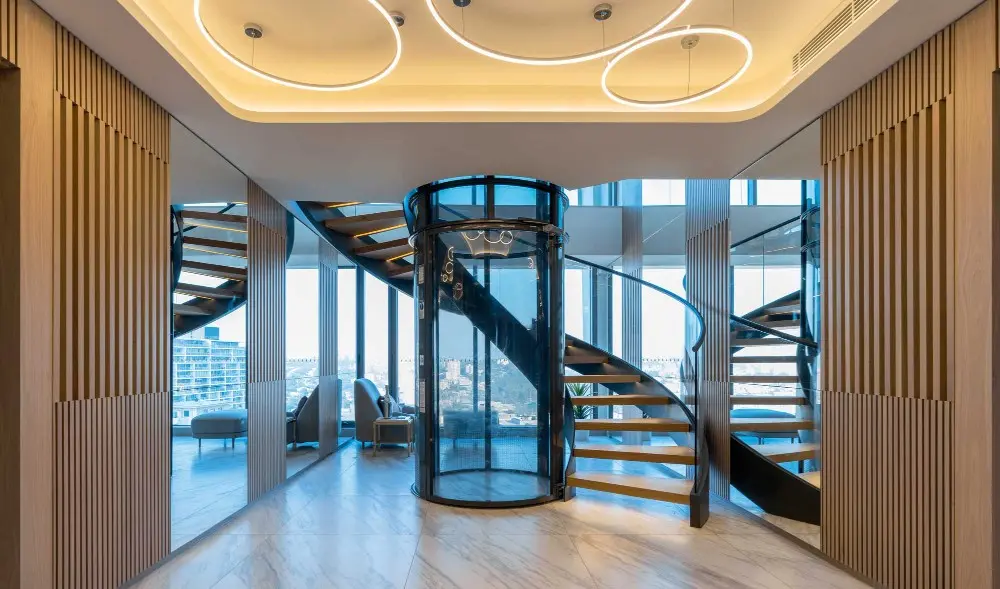 Luxury residential elevator with sleek design and modern spiral staircase for easy access.