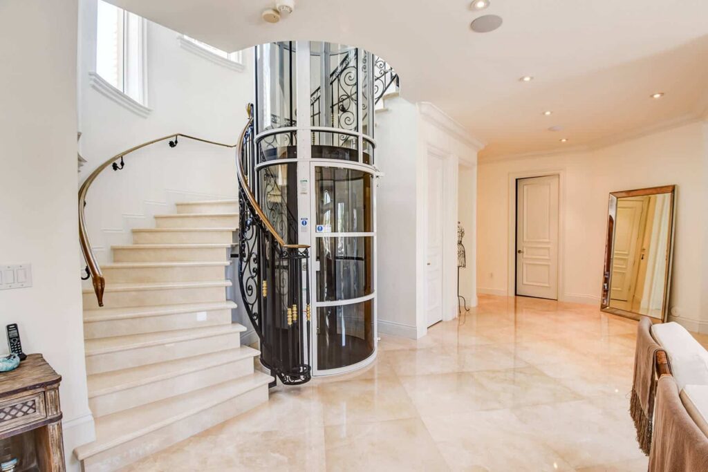 PVE30 pneumatic vacuum elevator beside a curved staircase in a Florida home