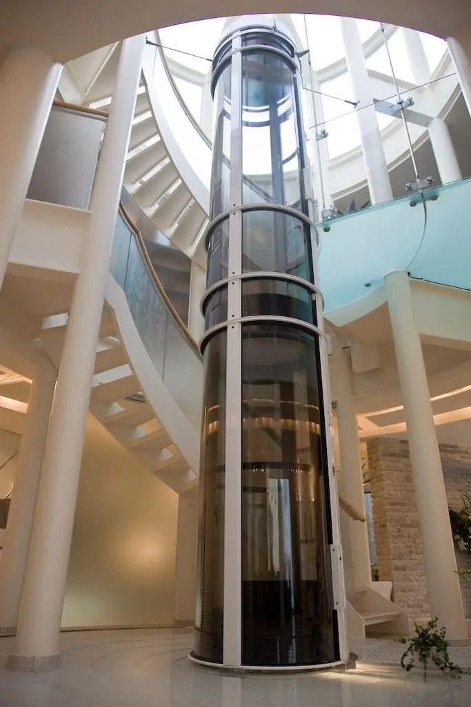 PVE37 pneumatic vacuum elevator installed beside a curved staircase in a modern Florida home