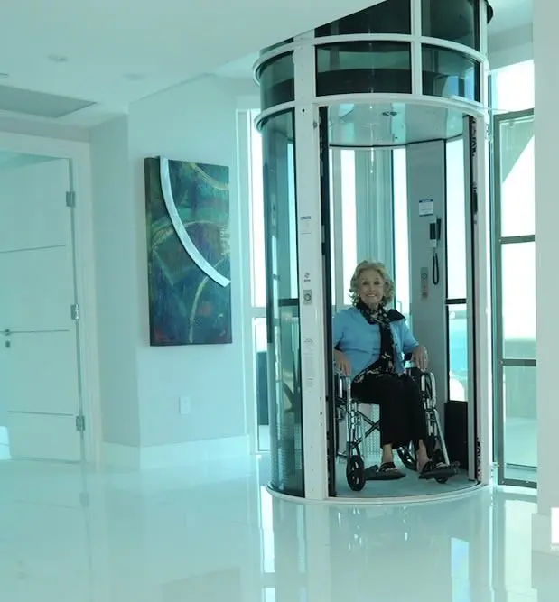 Wheelchair user inside a PVE52 pneumatic vacuum elevator in a modern Florida home