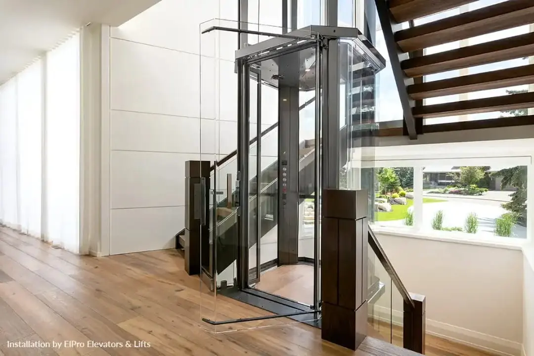 Modern Savaria VueLift glass home elevator with transparent enclosure and open staircase in Florida