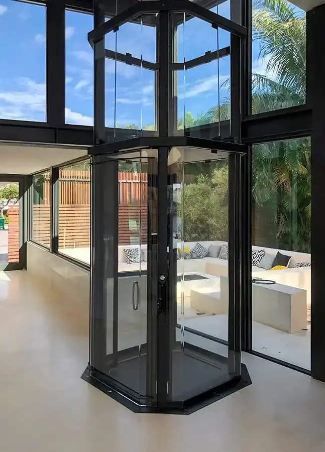 Luxury Savaria VueLift octagonal acrylic residential elevator in a contemporary Florida home
