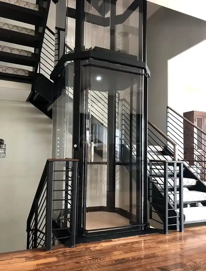Panoramic Savaria VueLift octagonal residential elevator beside a modern staircase in Florida