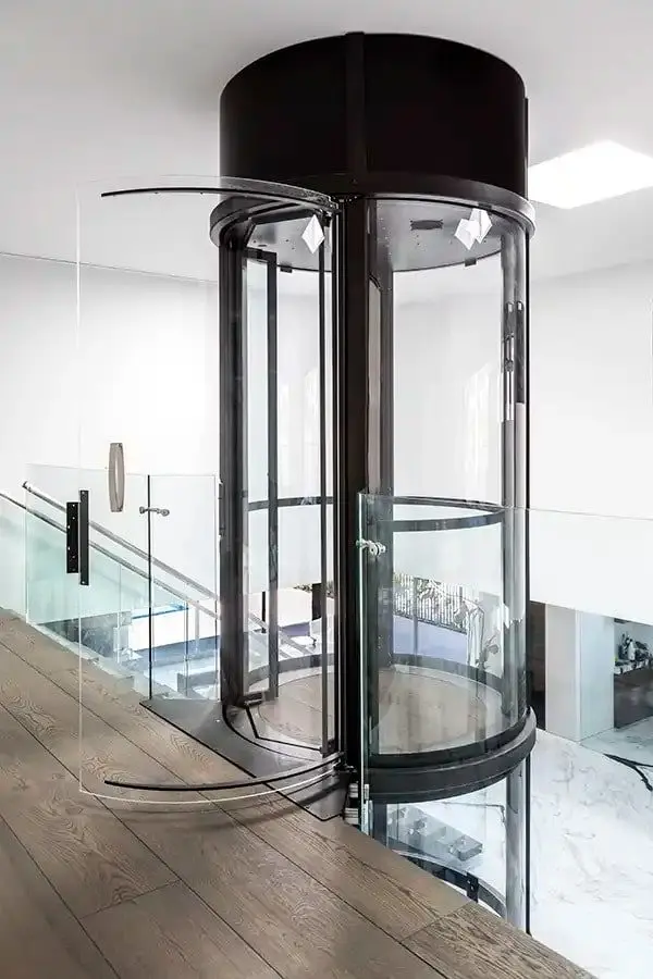 Savaria VueLift round panoramic glass home elevator with black frame in a contemporary Florida residence